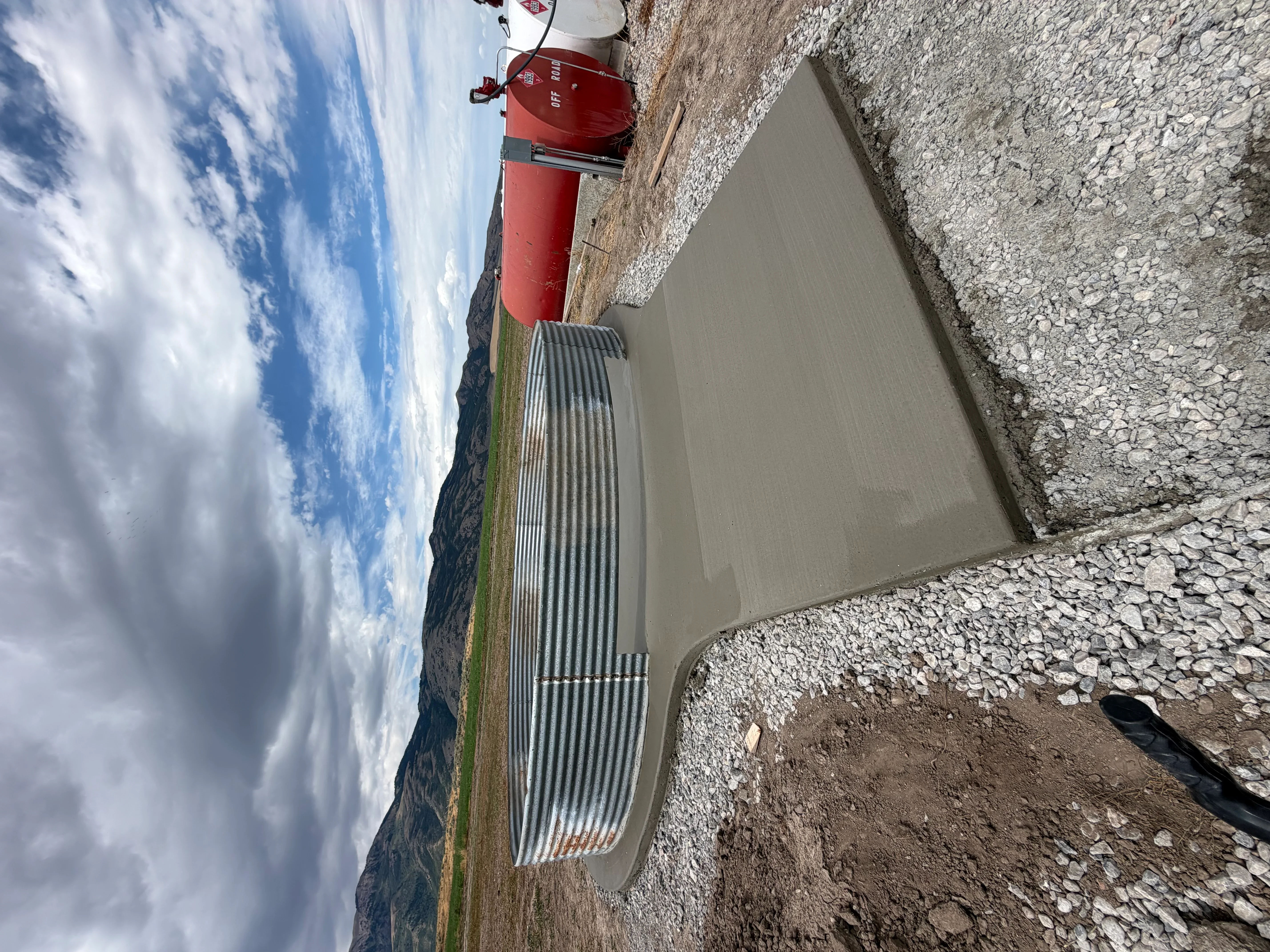 Finished concrete pad with smooth troweled surface and proper drainage slope