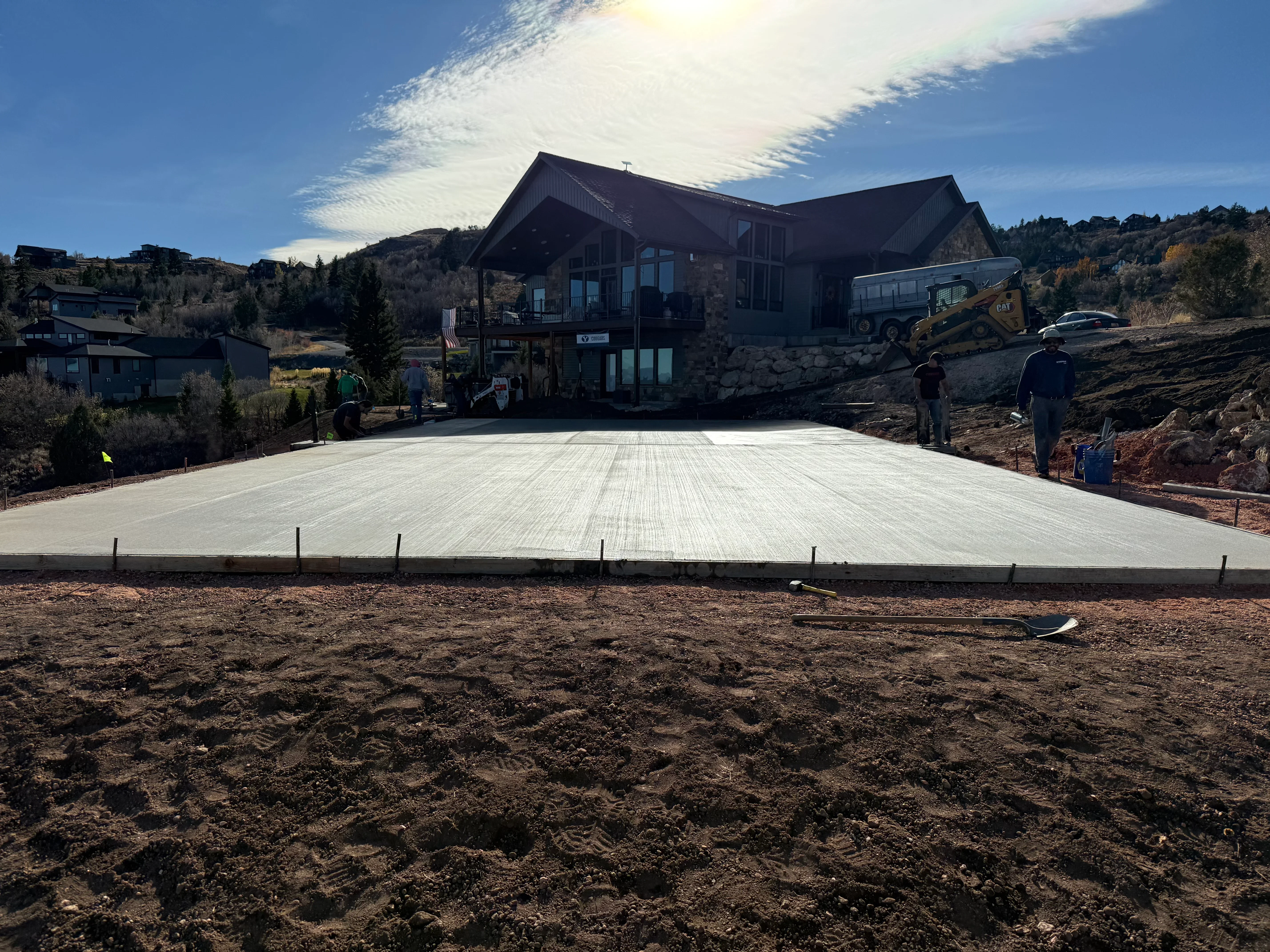 Finished concrete driveway with broom finish texture and perimeter forms in front of residential home