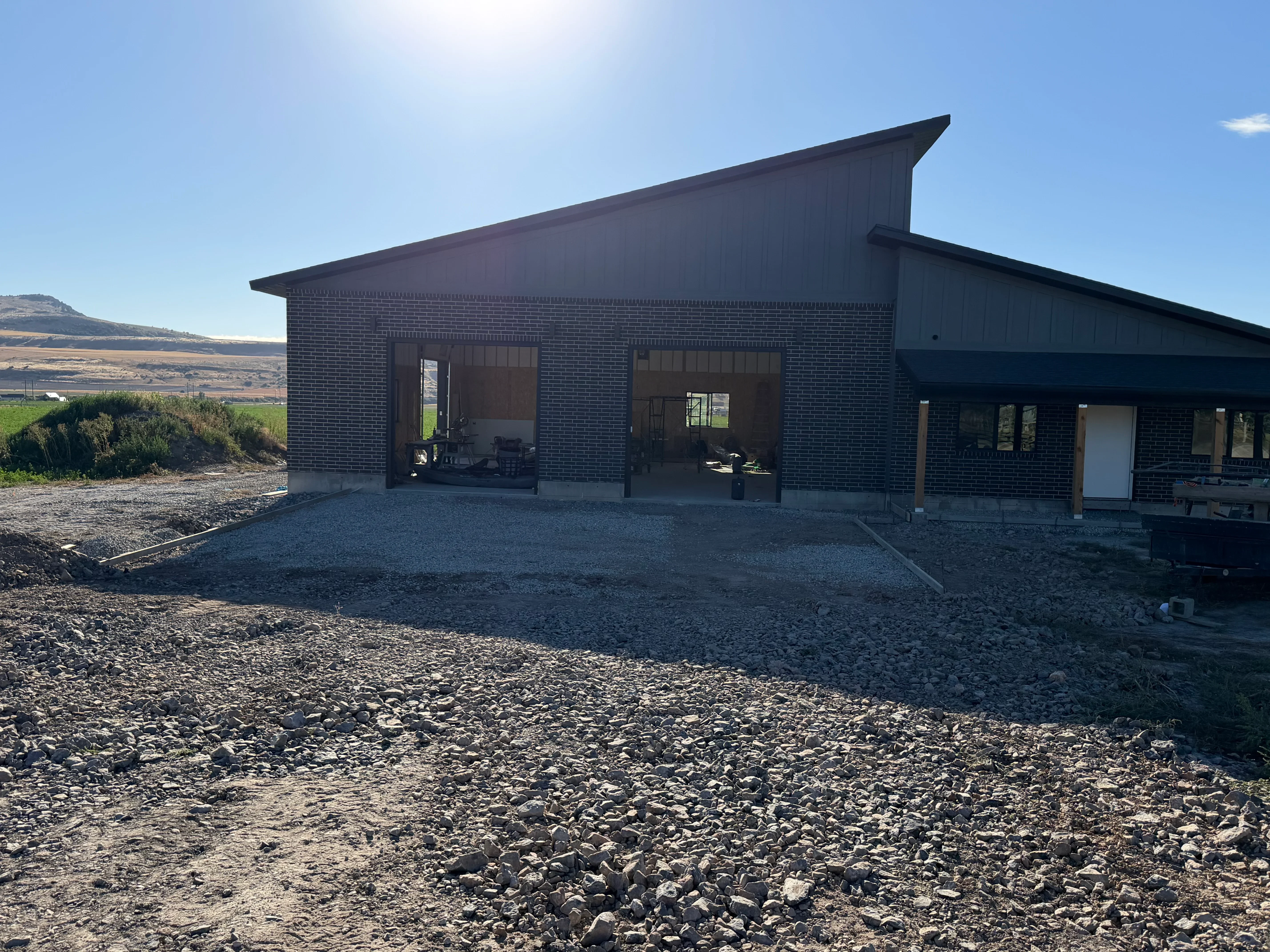 Concrete driveway and site work for modern brick residential home with metal roof