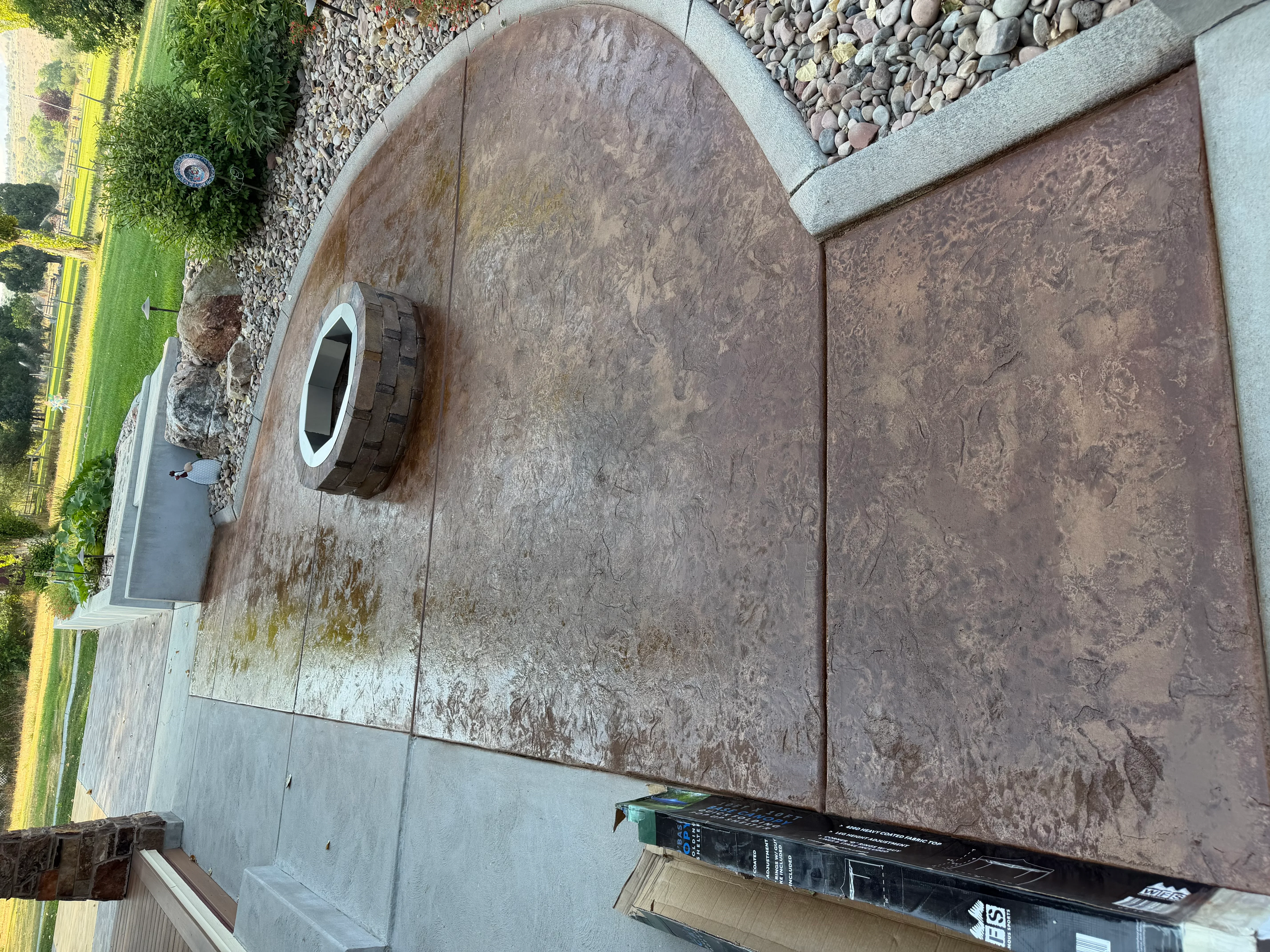 Stamped concrete patio with brown stone texture pattern and curved border detail