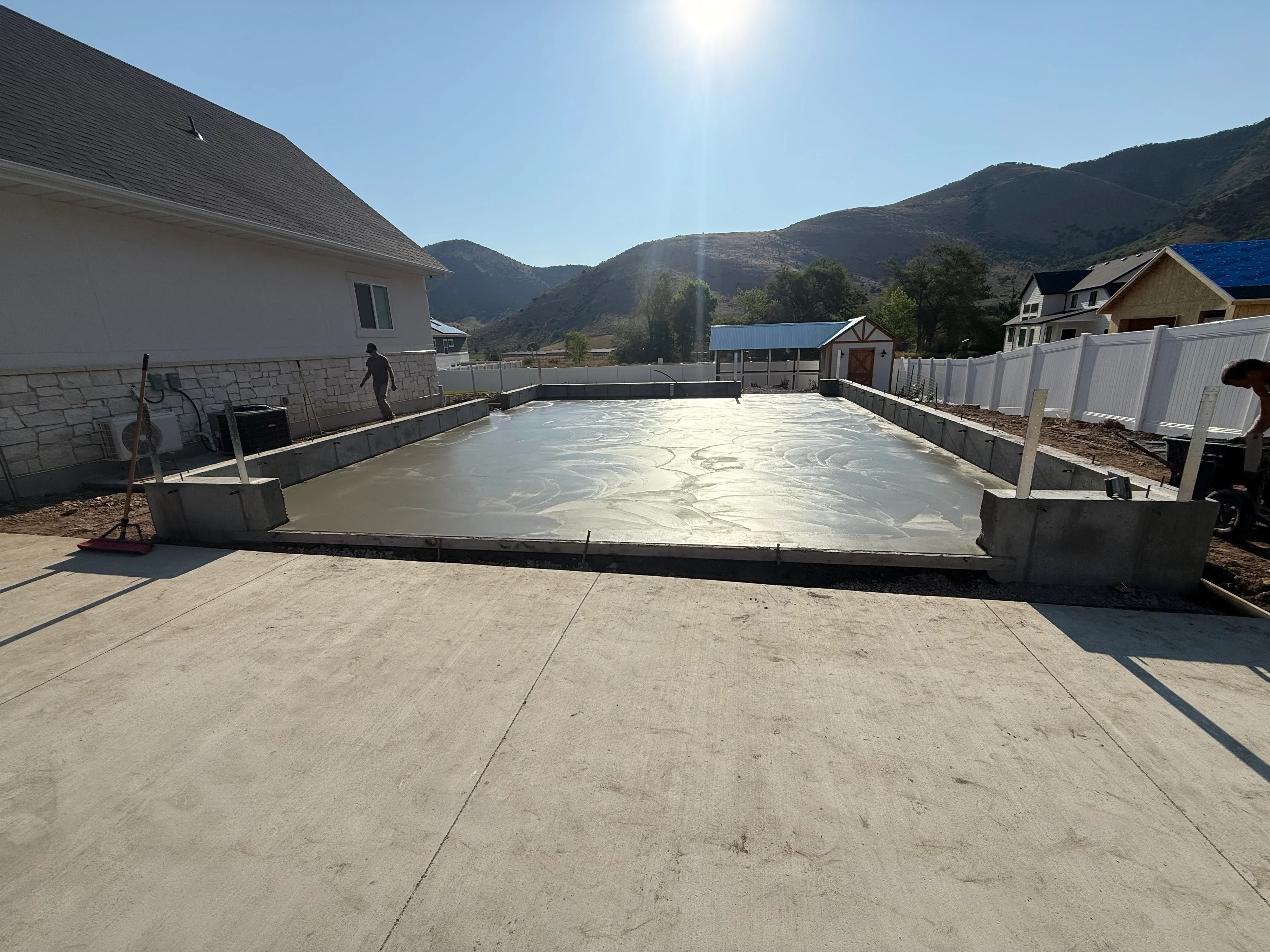 Finished concrete pool foundation with smooth troweled surface and concrete retaining walls