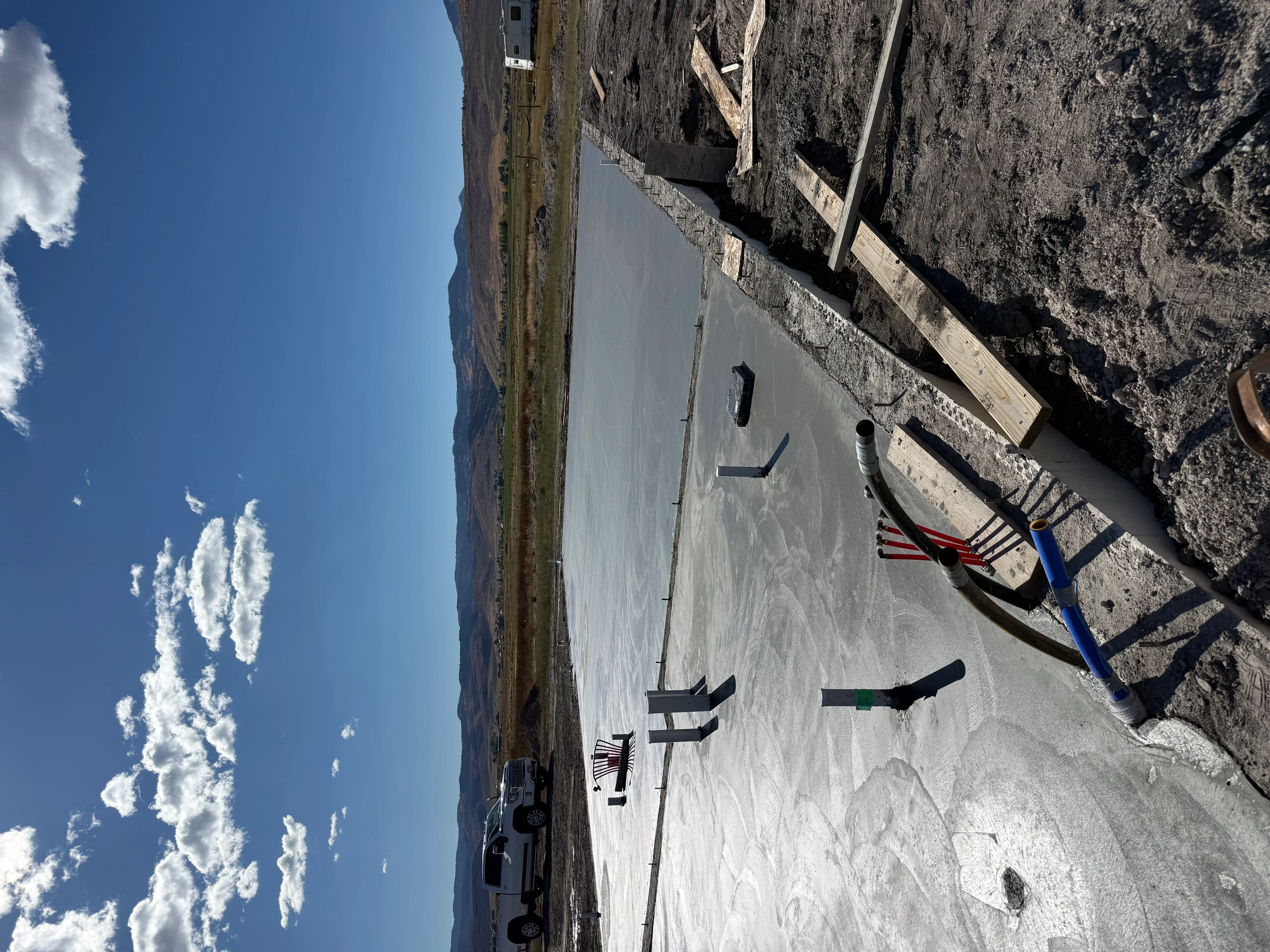 Newly poured concrete driveway with smooth finish and proper slope for drainage