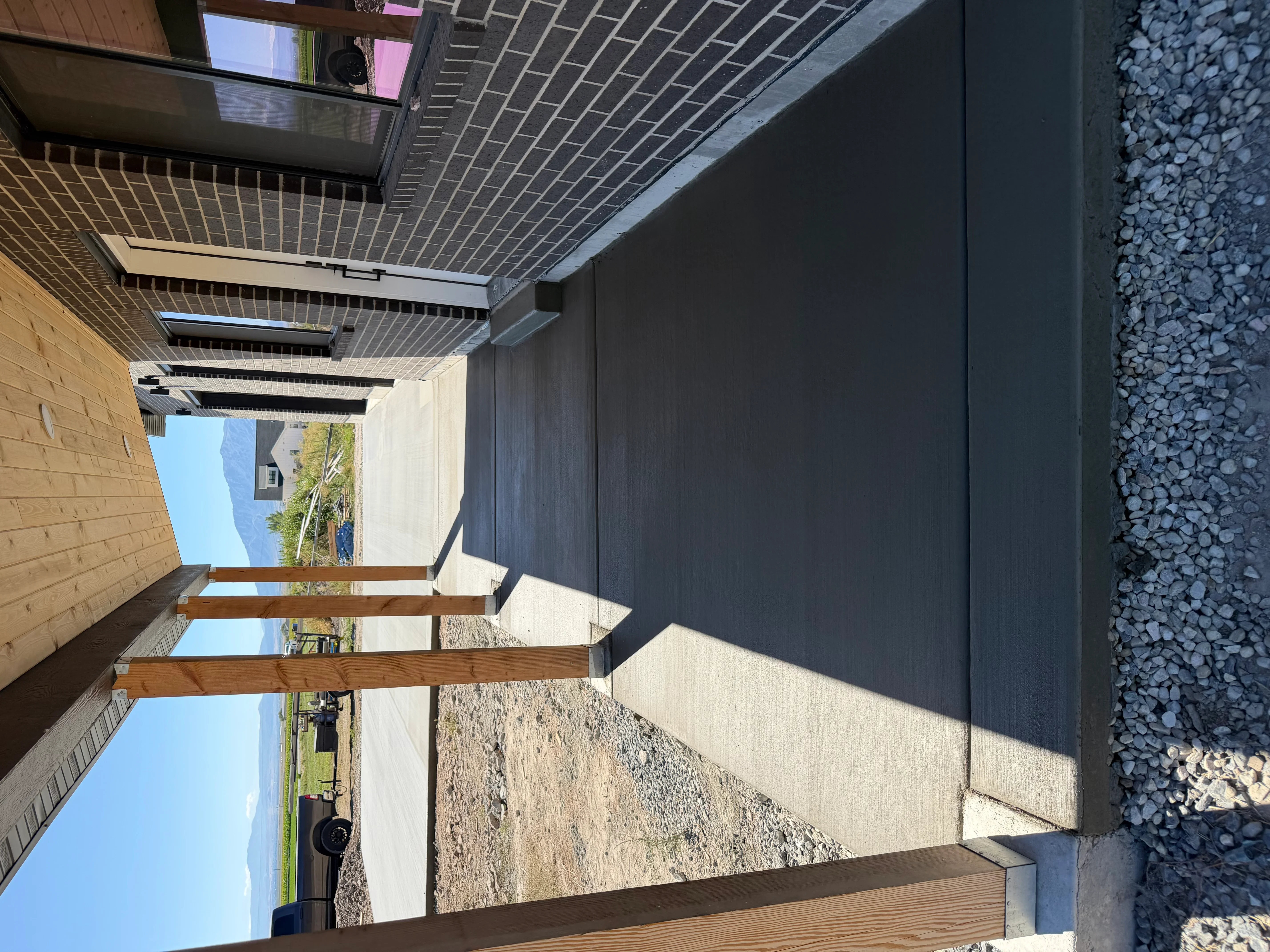 Concrete foundation pad with gravel drainage, wood beam framing, and metal roof installation