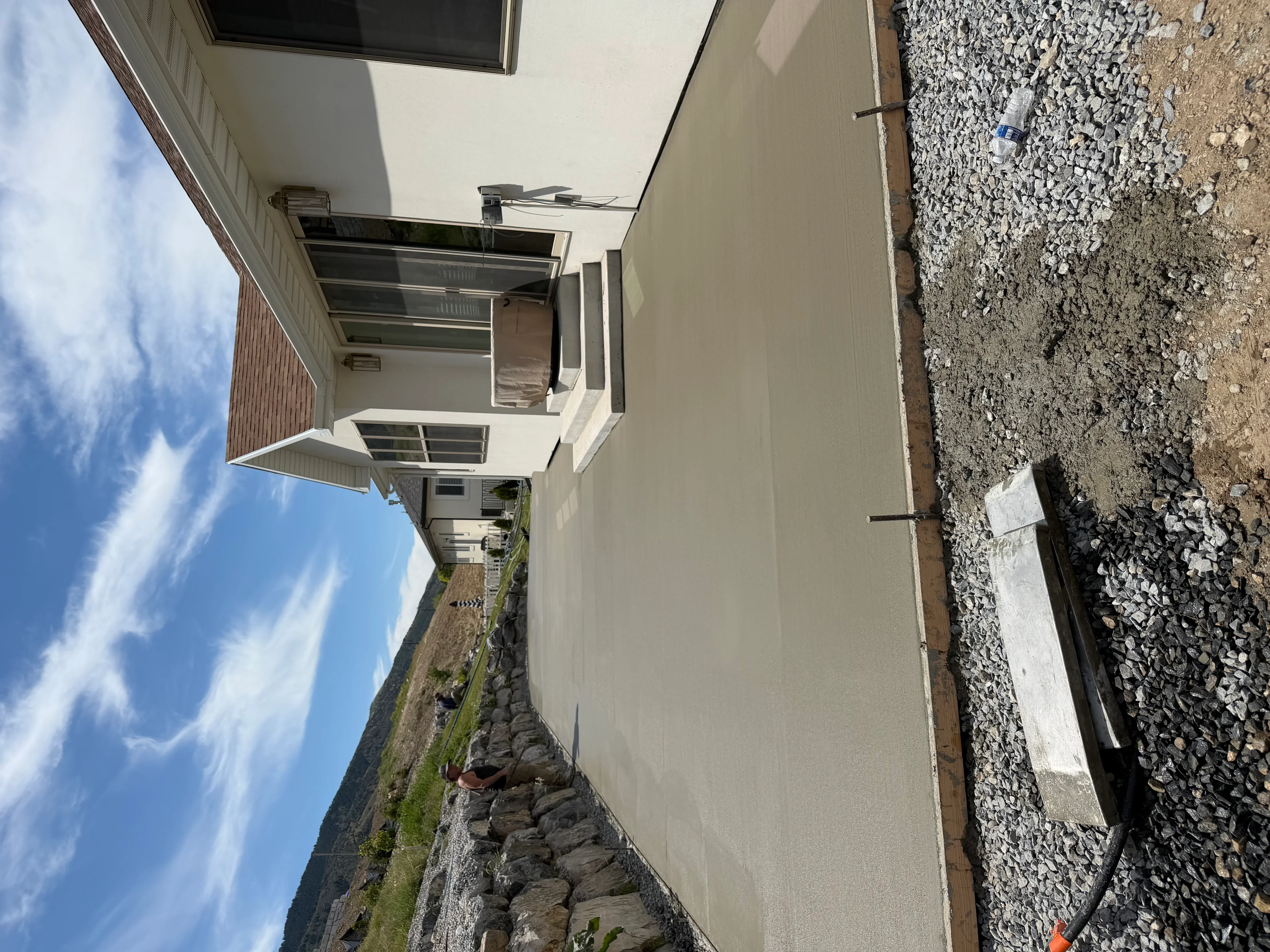 Newly poured concrete driveway with finished surface and proper slope for drainage