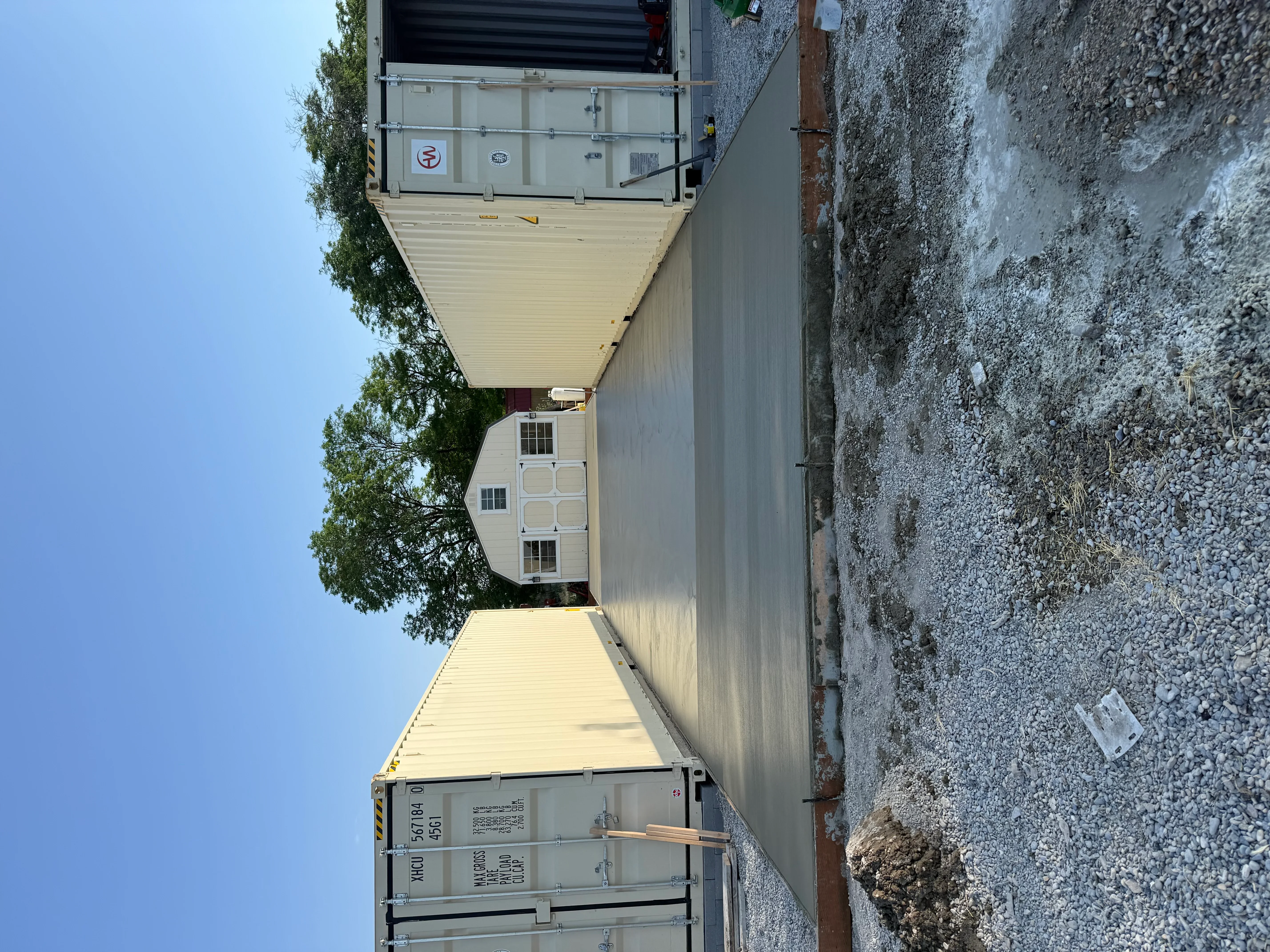Finished concrete driveway with smooth gray surface leading to residential garage