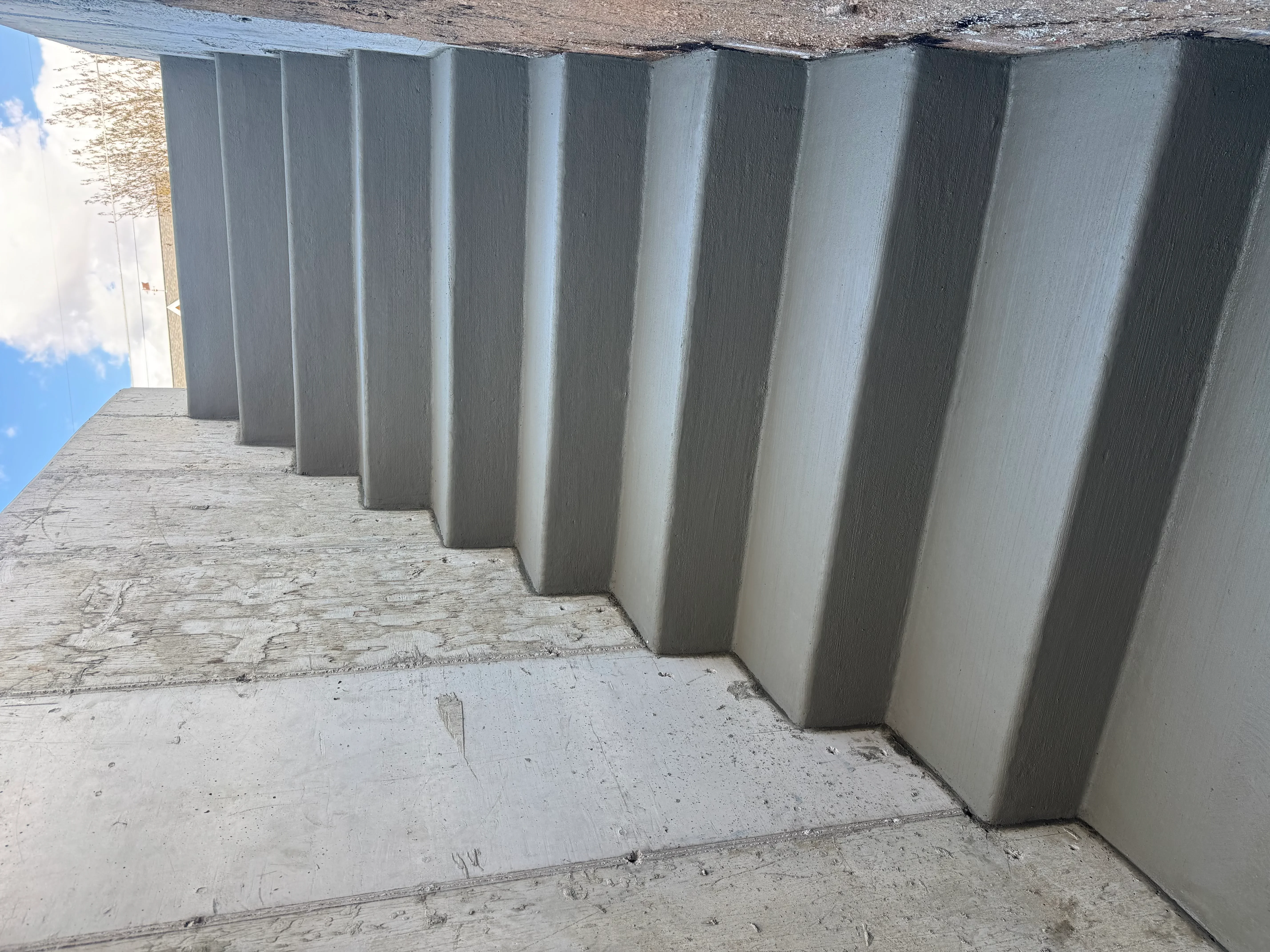 Vertical concrete foundation walls with ribbed texture and clean construction joints